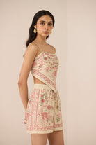 Woman wearing a floral two-piece outfit on a beige background Calling June