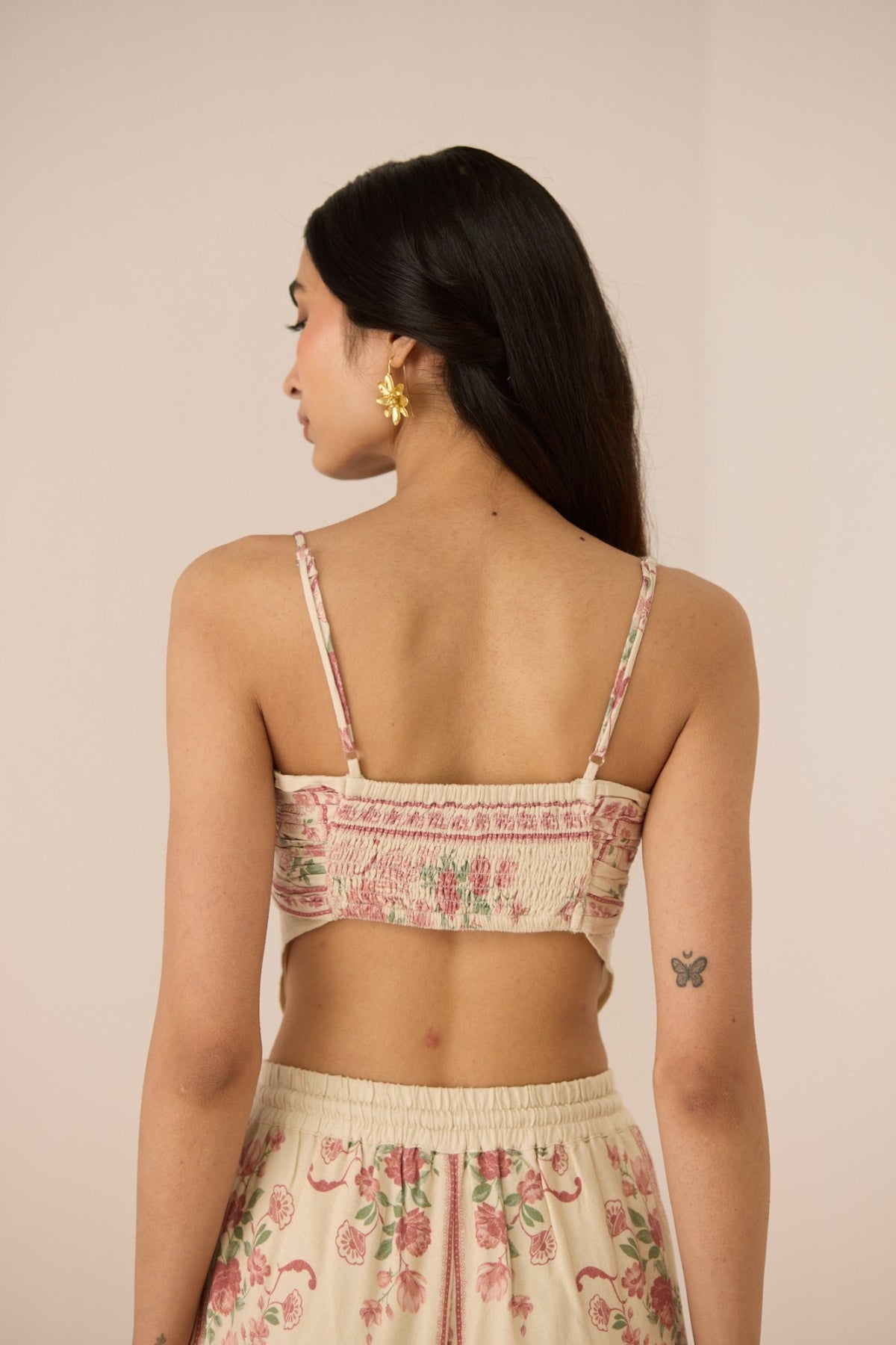 Woman wearing a floral top and skirt set against a plain background Calling June