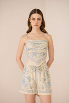 Woman wearing a floral set against a beige background Calling June