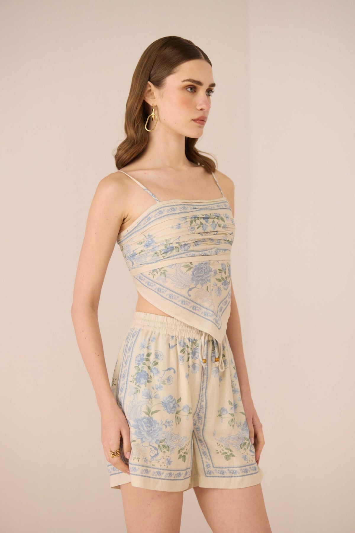 Woman wearing a floral set and shorts set on a beige background Calling June