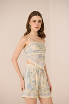 Woman wearing a floral dress and shorts on a beige background Calling June