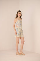 Woman wearing a patterned dress and shorts on a beige background Calling June