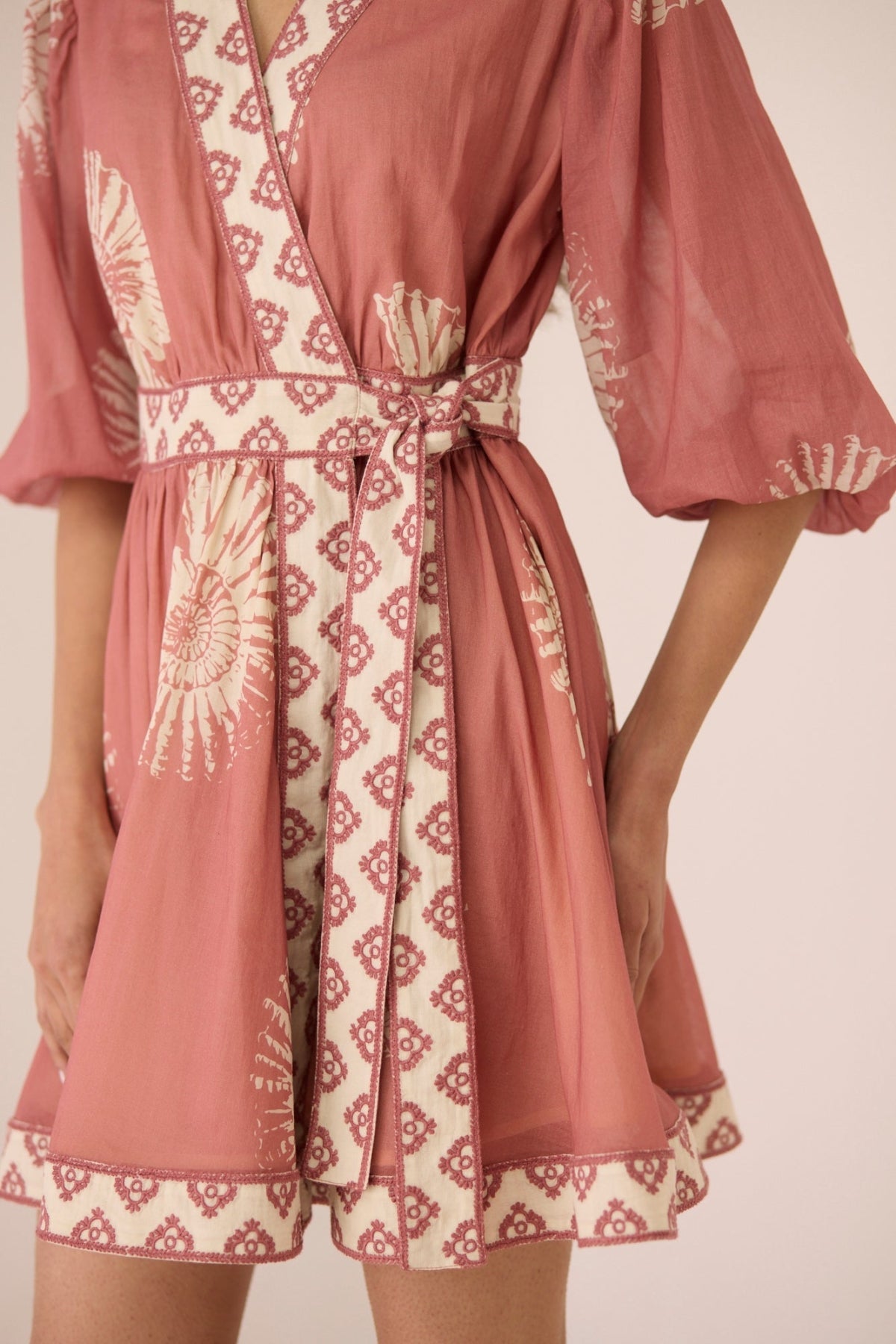 Pink and white patterned dress with long sleeves on a neutral background Calling June