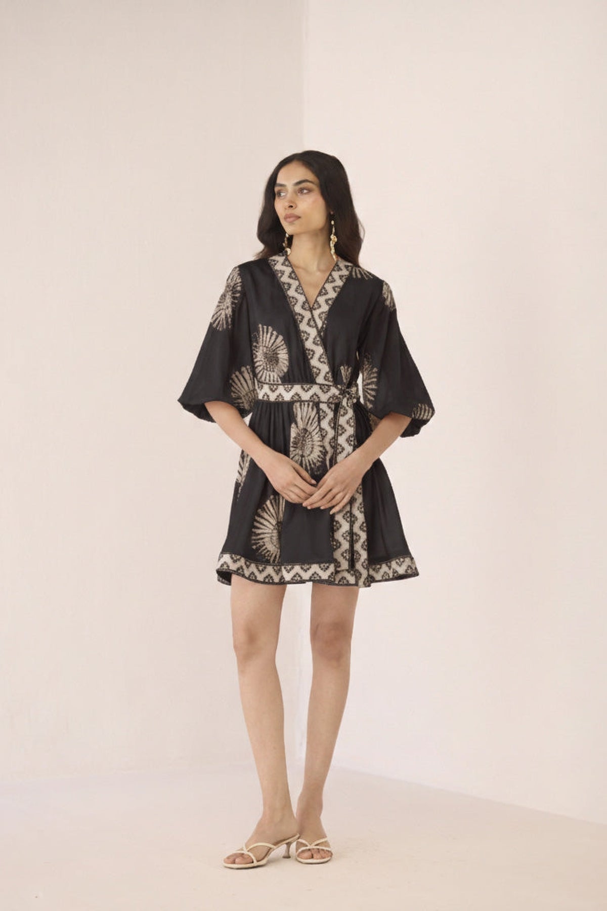 Woman wearing a black and white patterned dress on a beige background Calling June