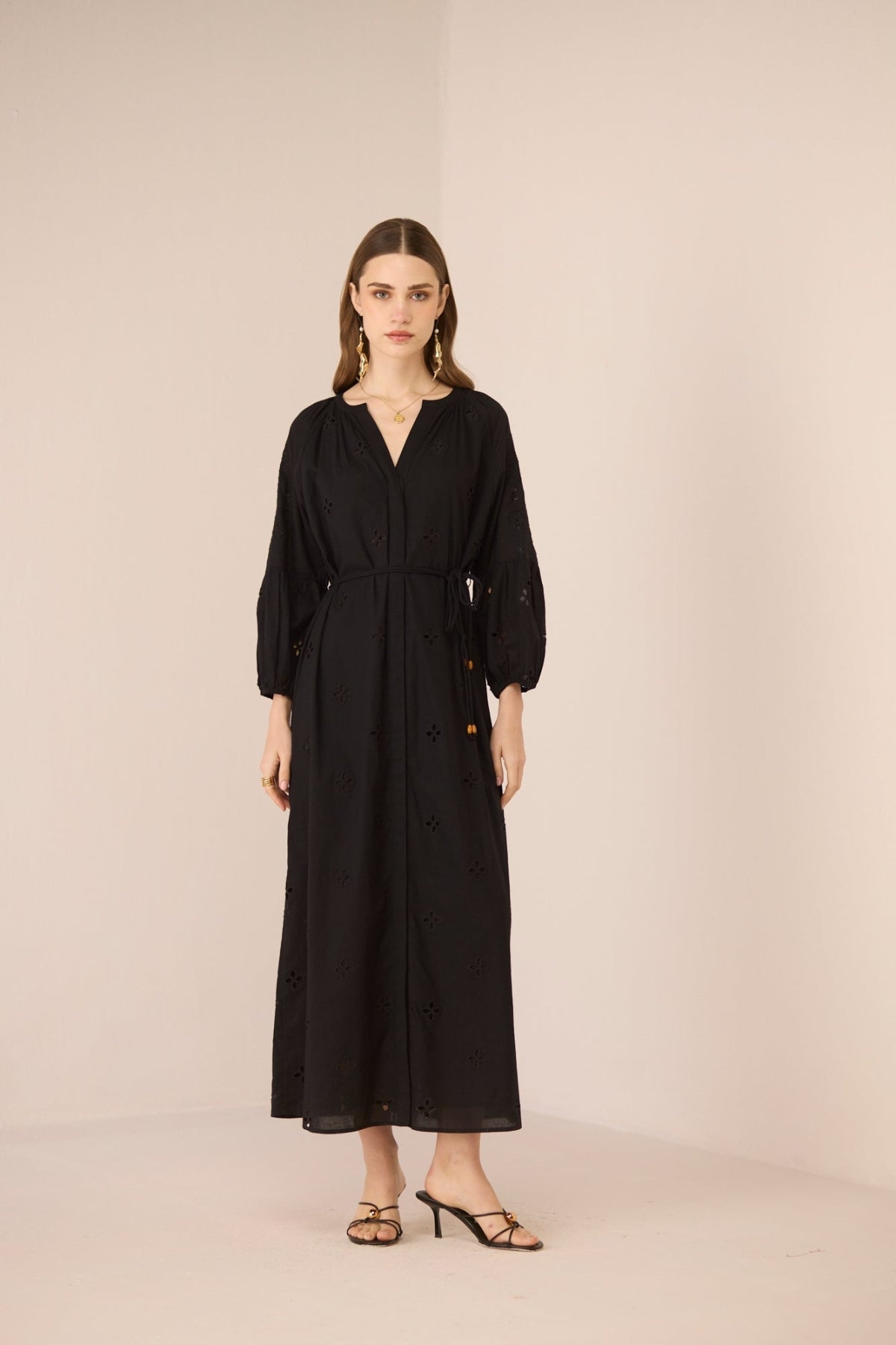 Woman wearing a black dress on a beige background Calling June