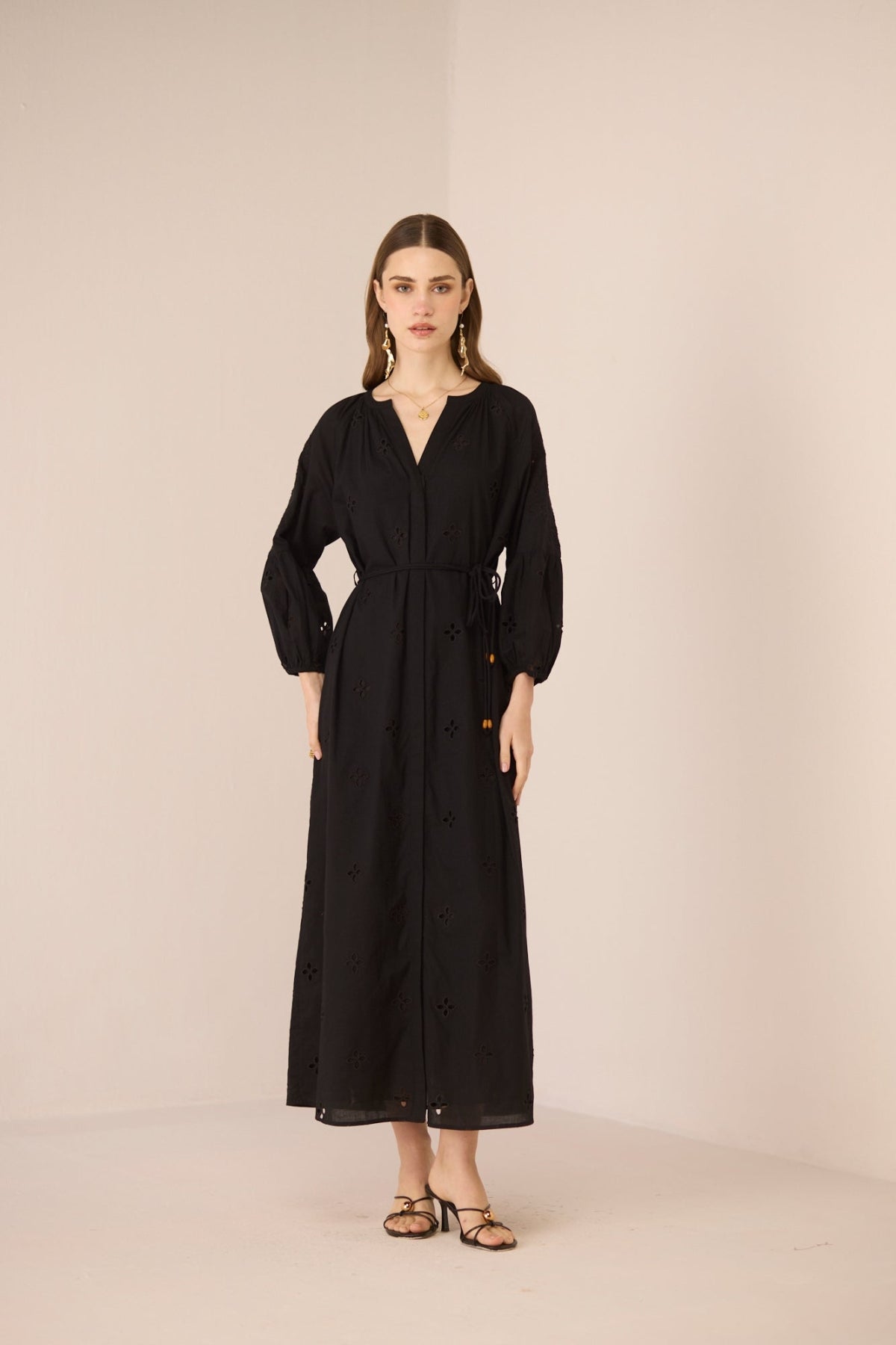 Woman wearing a black dress against a beige background Calling June