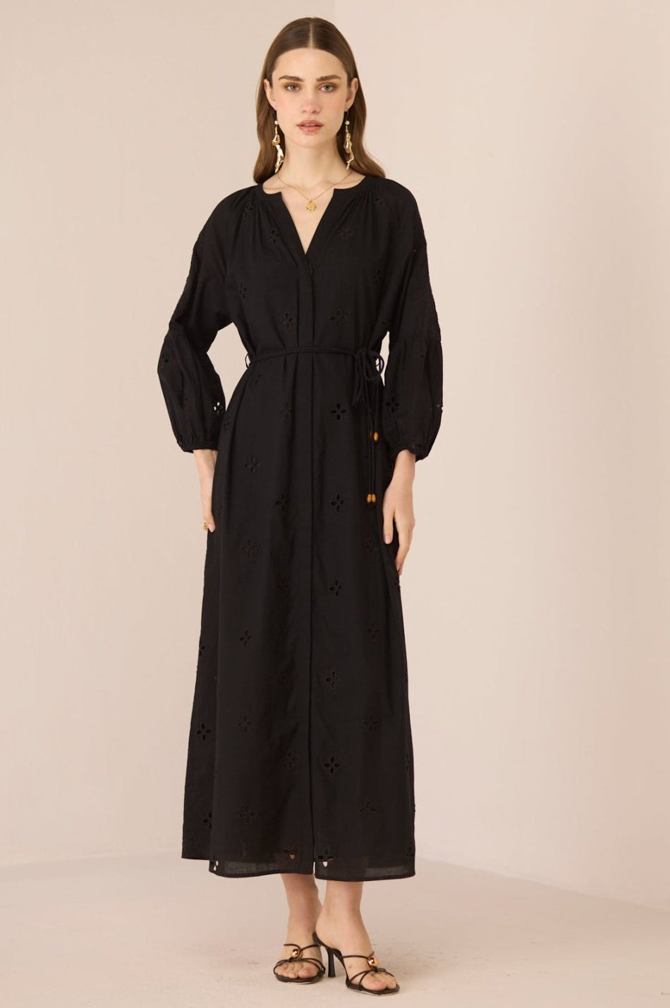 Woman wearing a black dress against a beige background Calling June