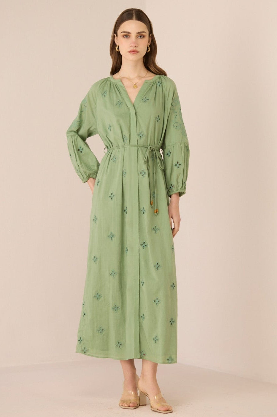 Woman wearing a green dress with floral patterns on a beige background Calling June