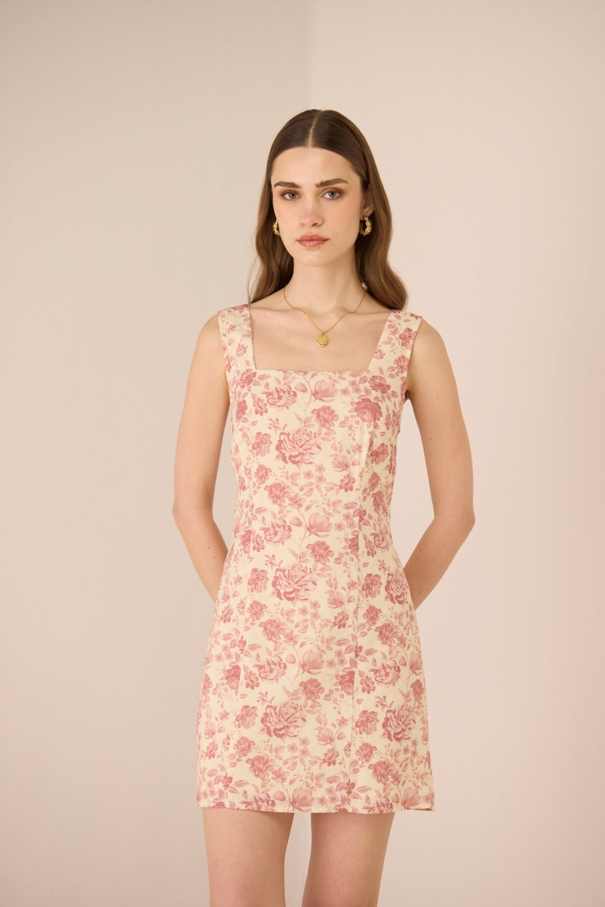Woman wearing a floral dress against a beige background Calling June