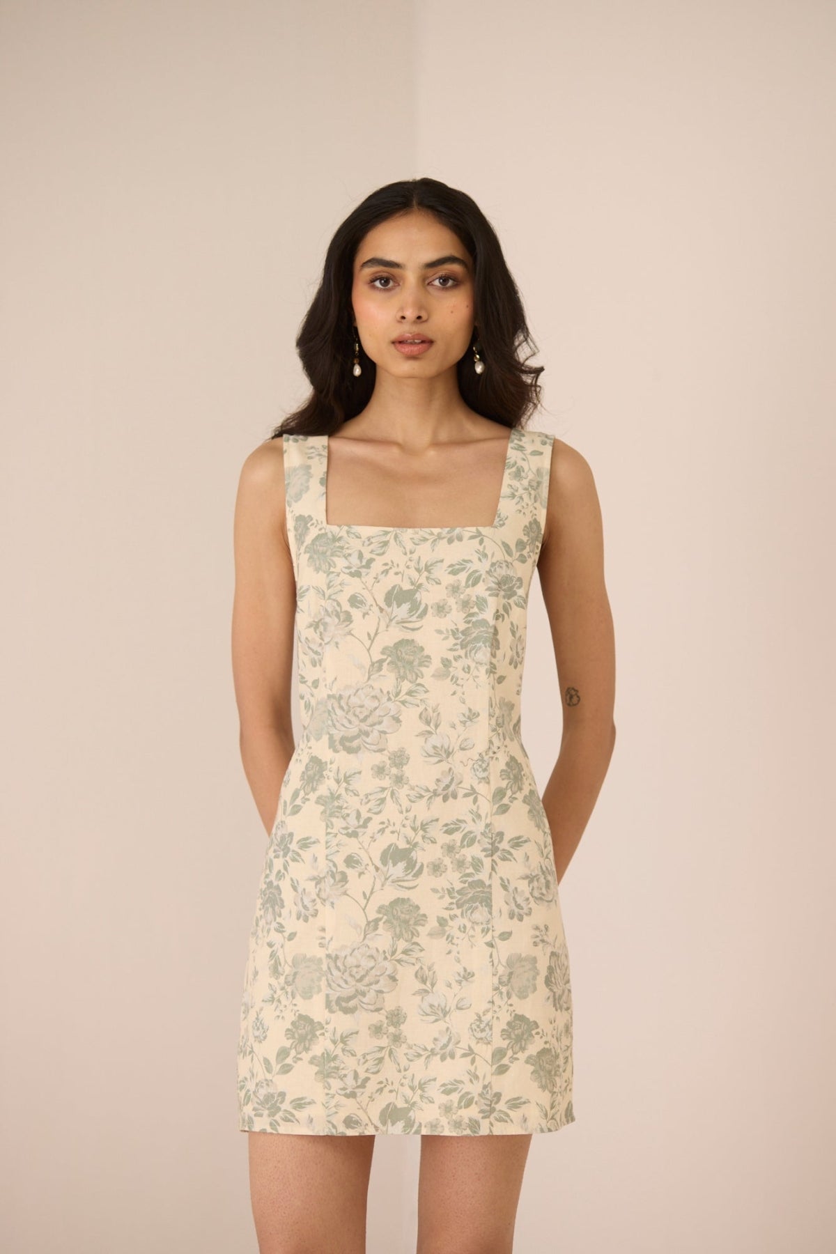Woman wearing a floral dress against a beige background Calling June
