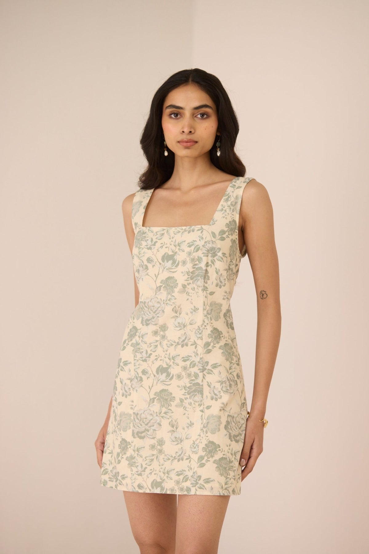 Woman wearing a floral dress against a plain background Calling June