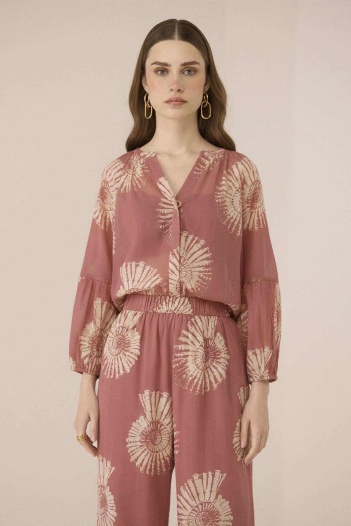 Woman wearing a pink floral dress against a beige background Calling June