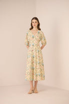 Woman wearing a floral dress against a plain background Calling June