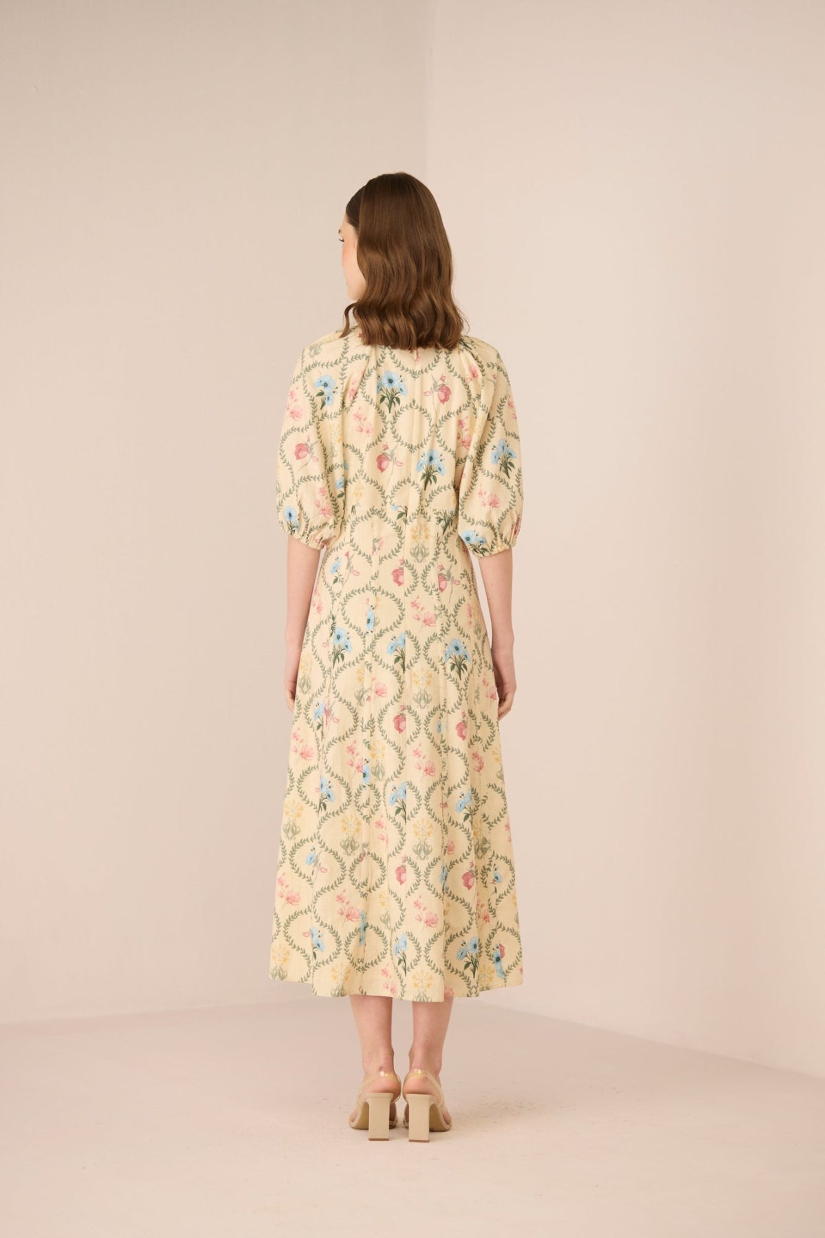 Woman wearing a floral dress on a beige background Calling June