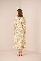 Woman wearing a floral dress on a beige background Calling June