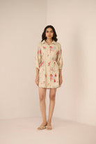 Woman wearing a floral dress on a beige background Calling June