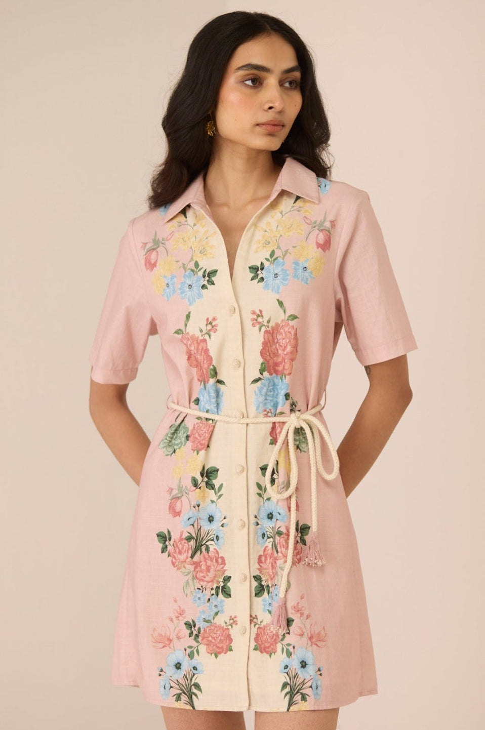 Woman wearing a pink floral dress against a beige background Calling June