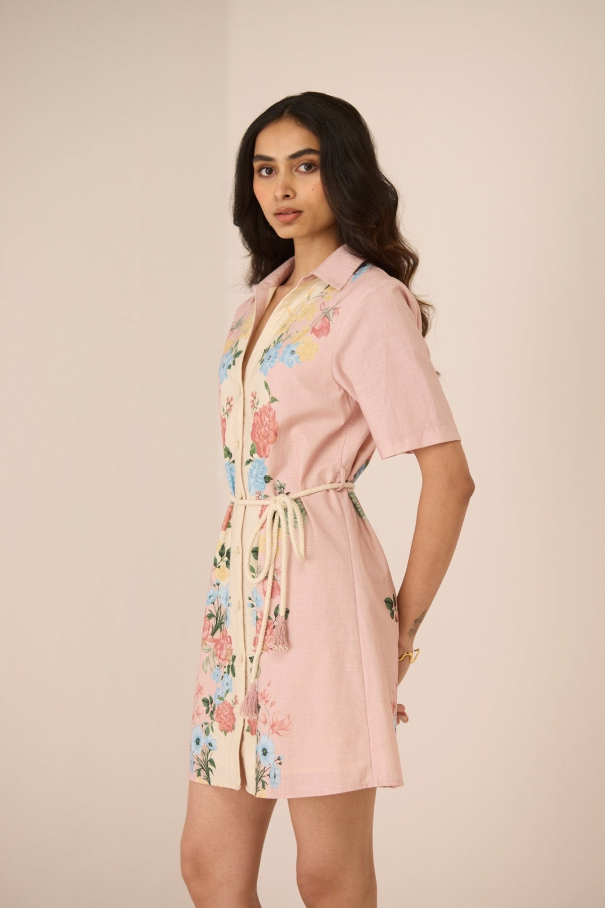 Woman wearing a pink floral robe against a beige background Calling June