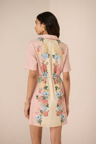 Woman wearing a floral dress with a plain background Calling June