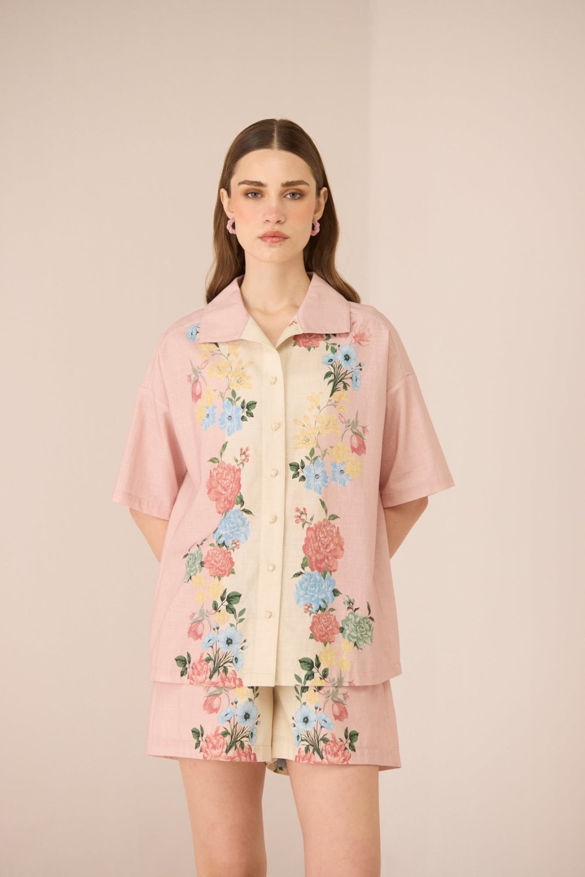 Woman wearing a pink floral outfit on a beige background Calling June