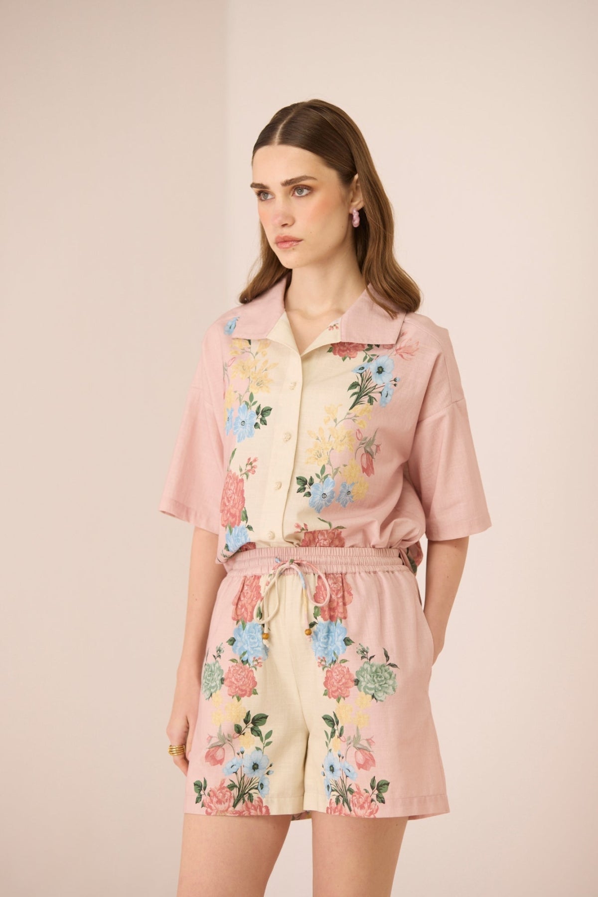 Woman wearing a floral outfit with a pink background Calling June