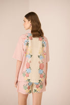 Woman wearing a floral shorts set with a beige background Calling June