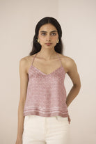 Woman wearing a pink patterned top against a beige background Calling June