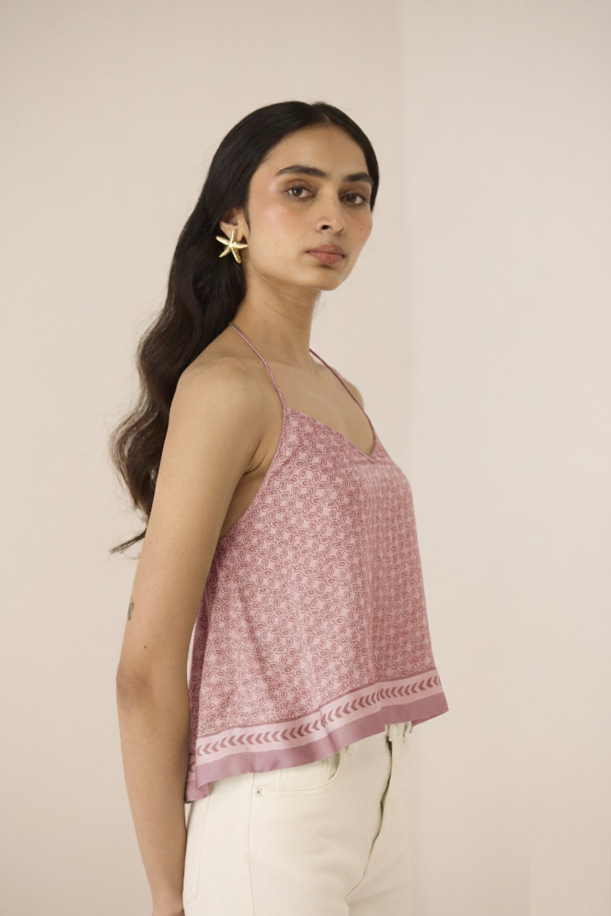 Woman wearing a pink floral top against a beige background Calling June