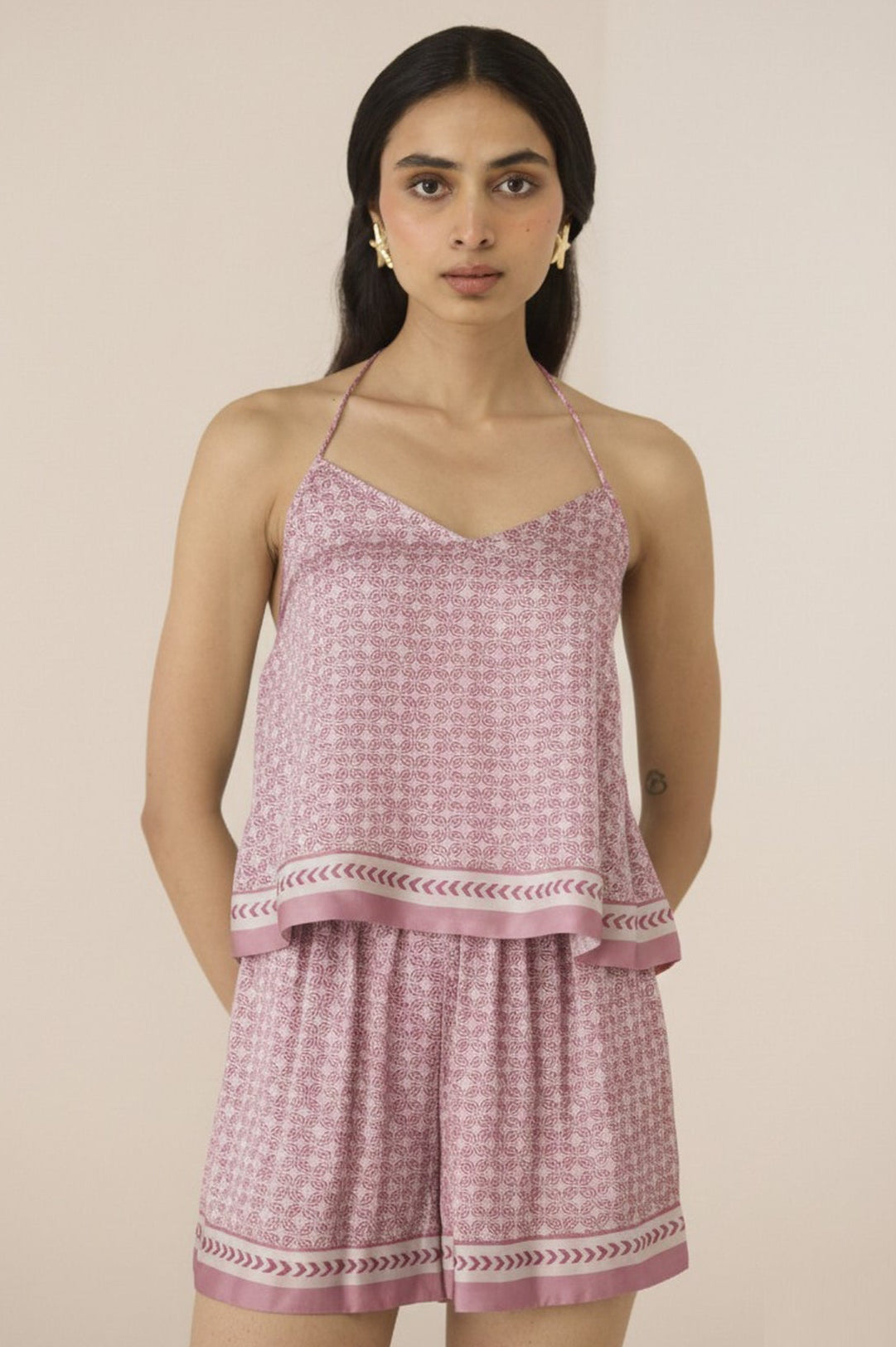 Woman wearing a pink checkered outfit with a plain background Calling June