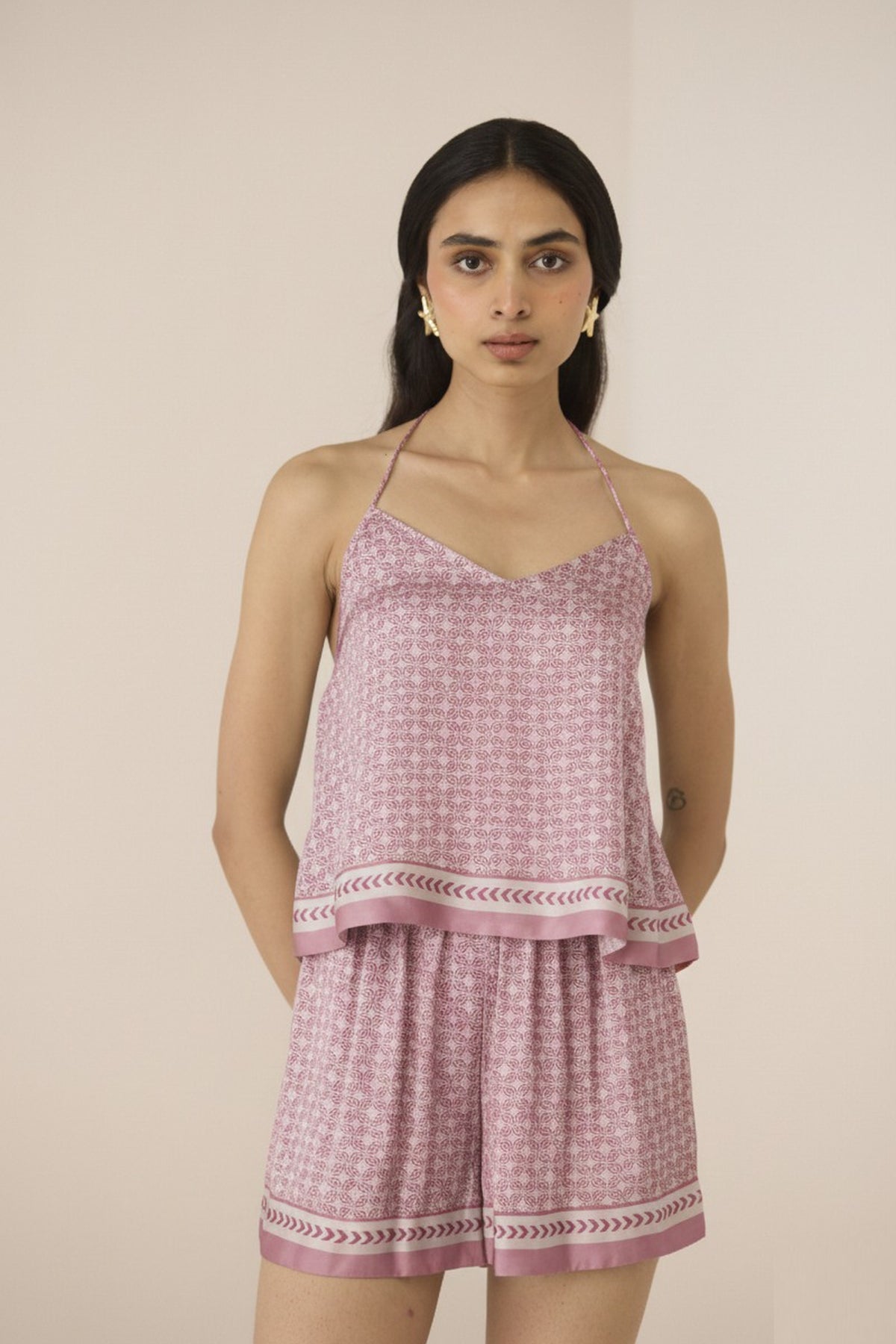 Woman wearing a pink checkered outfit with a plain background Calling June