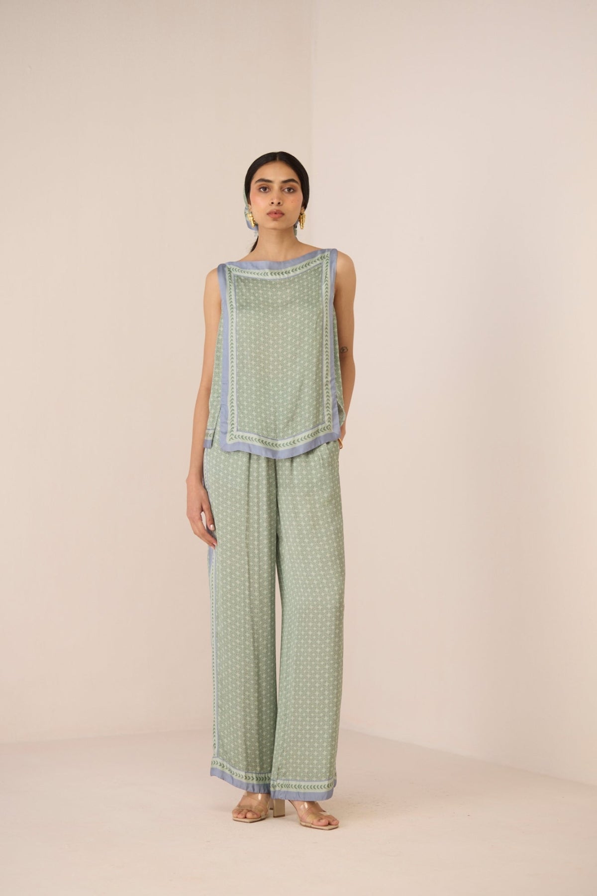 Woman wearing a green patterned outfit on a beige background Calling June