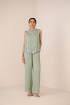 Woman wearing a green patterned outfit on a beige background Calling June