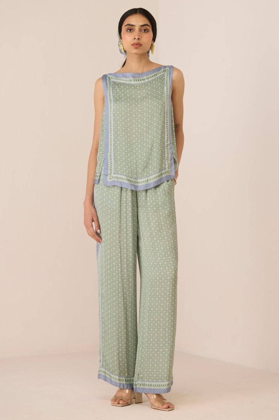 Woman wearing a green patterned outfit on a beige background Calling June